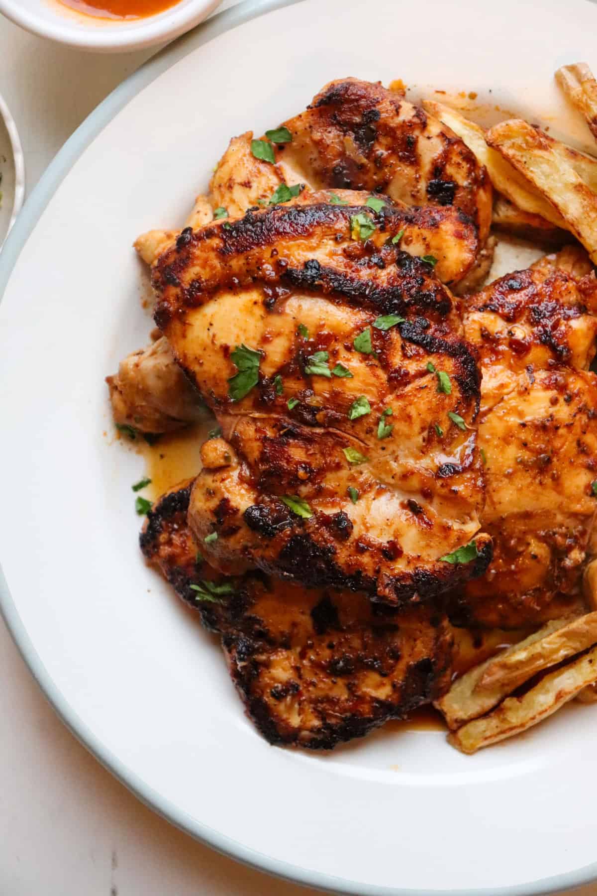 homemade nandos peri peri chicken on a white plate.