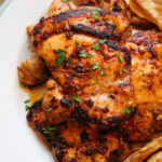 up close of plate of seasoned chicken thighs.