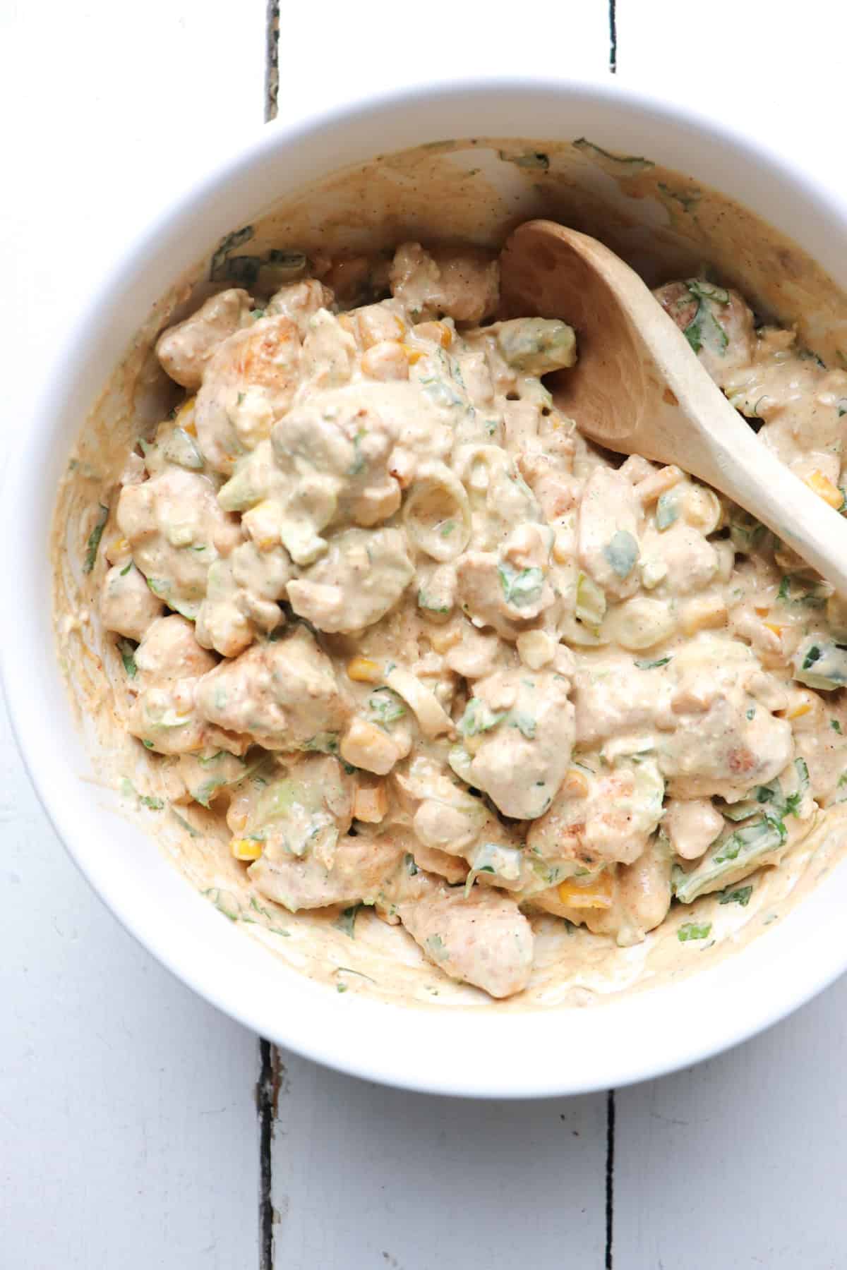 Chicken and salad dressing in bowl to make elotes chicken salad.