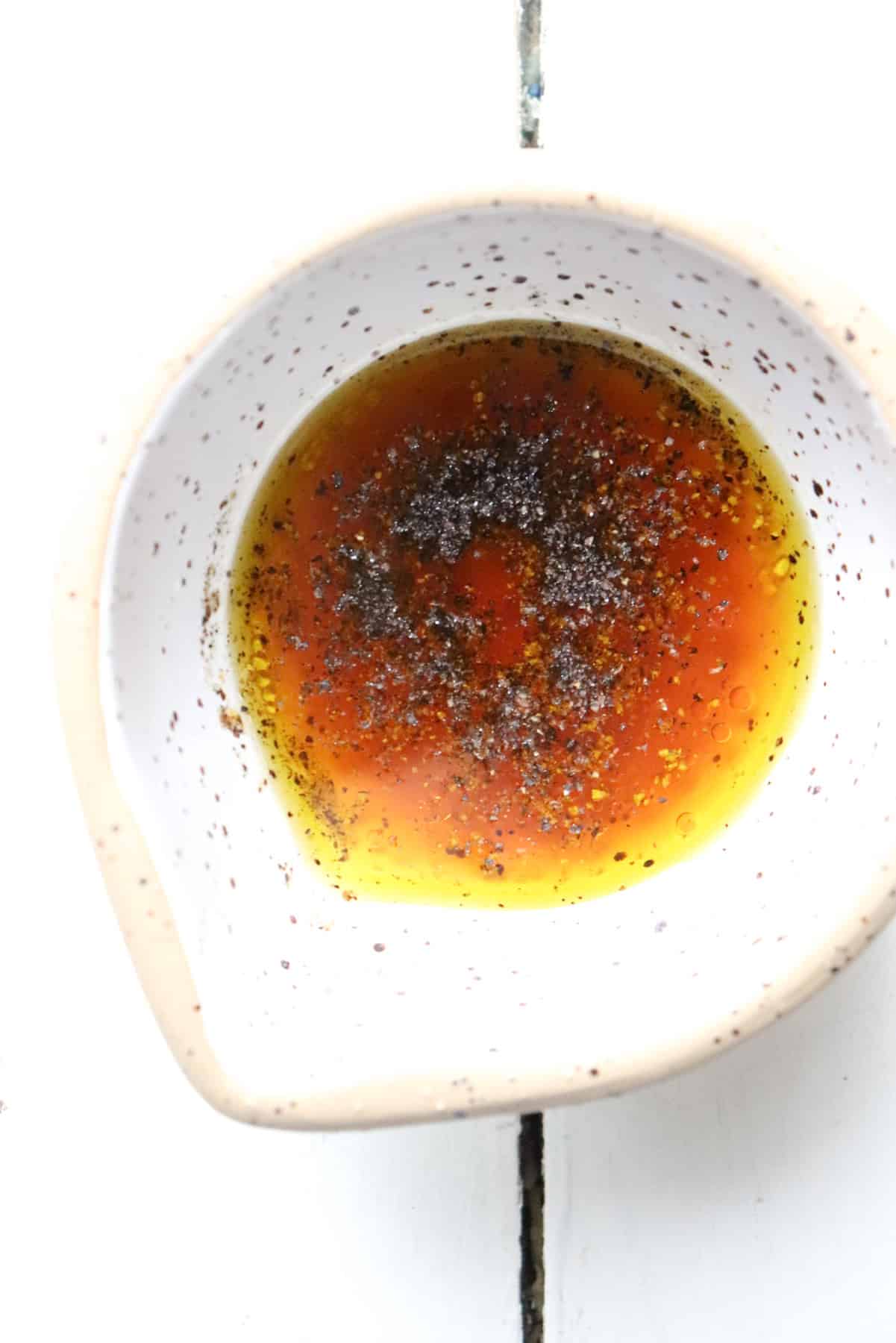 vinaigrette ingredients in a small white bowl.
