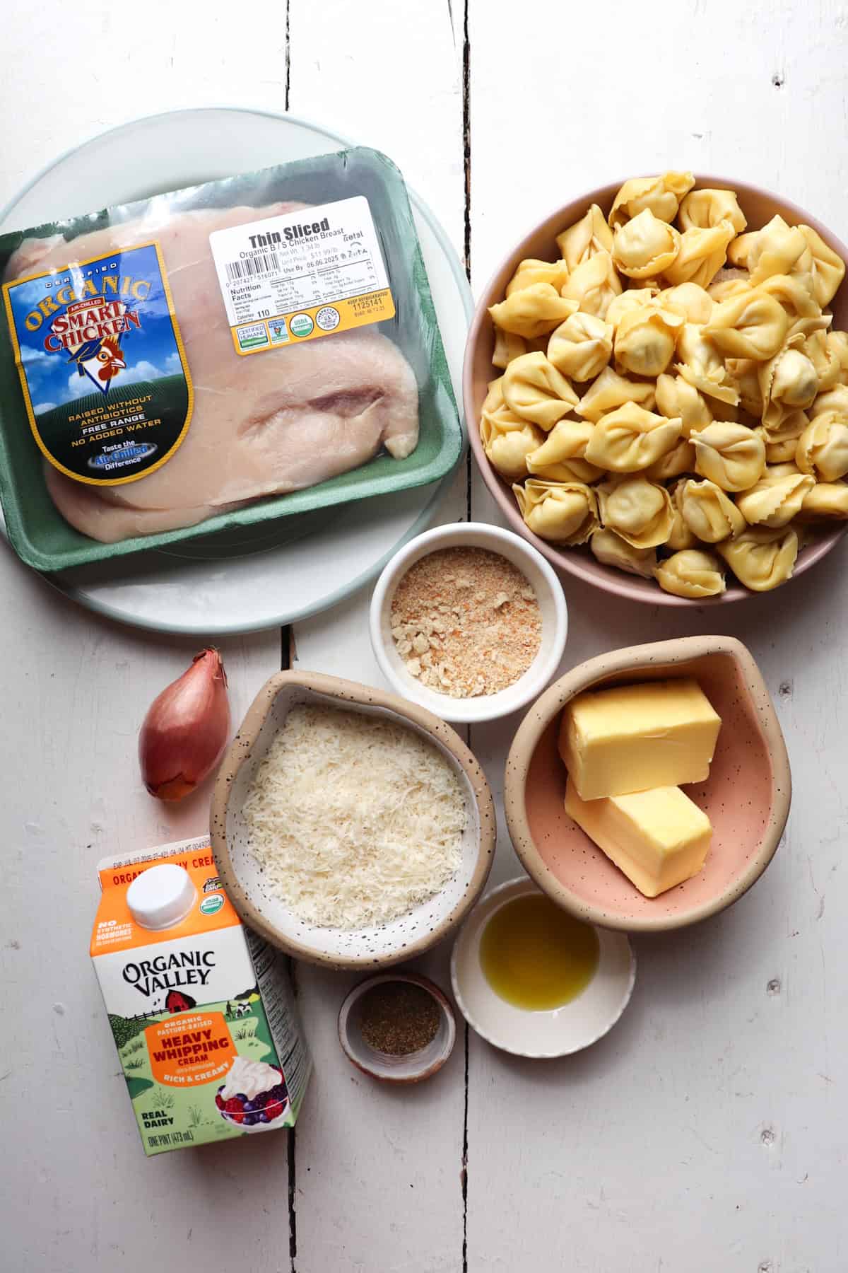 Ingredients for olive garden chicken and tortellini on a white table.