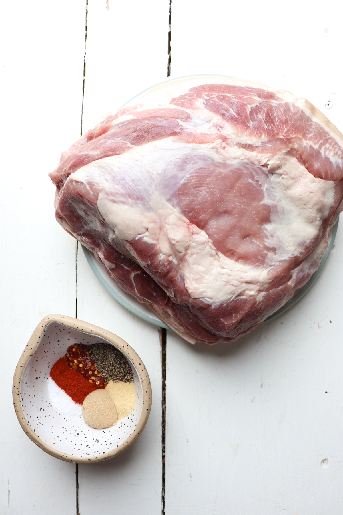 ingredients for oven roasted pork shoulder on a white table.