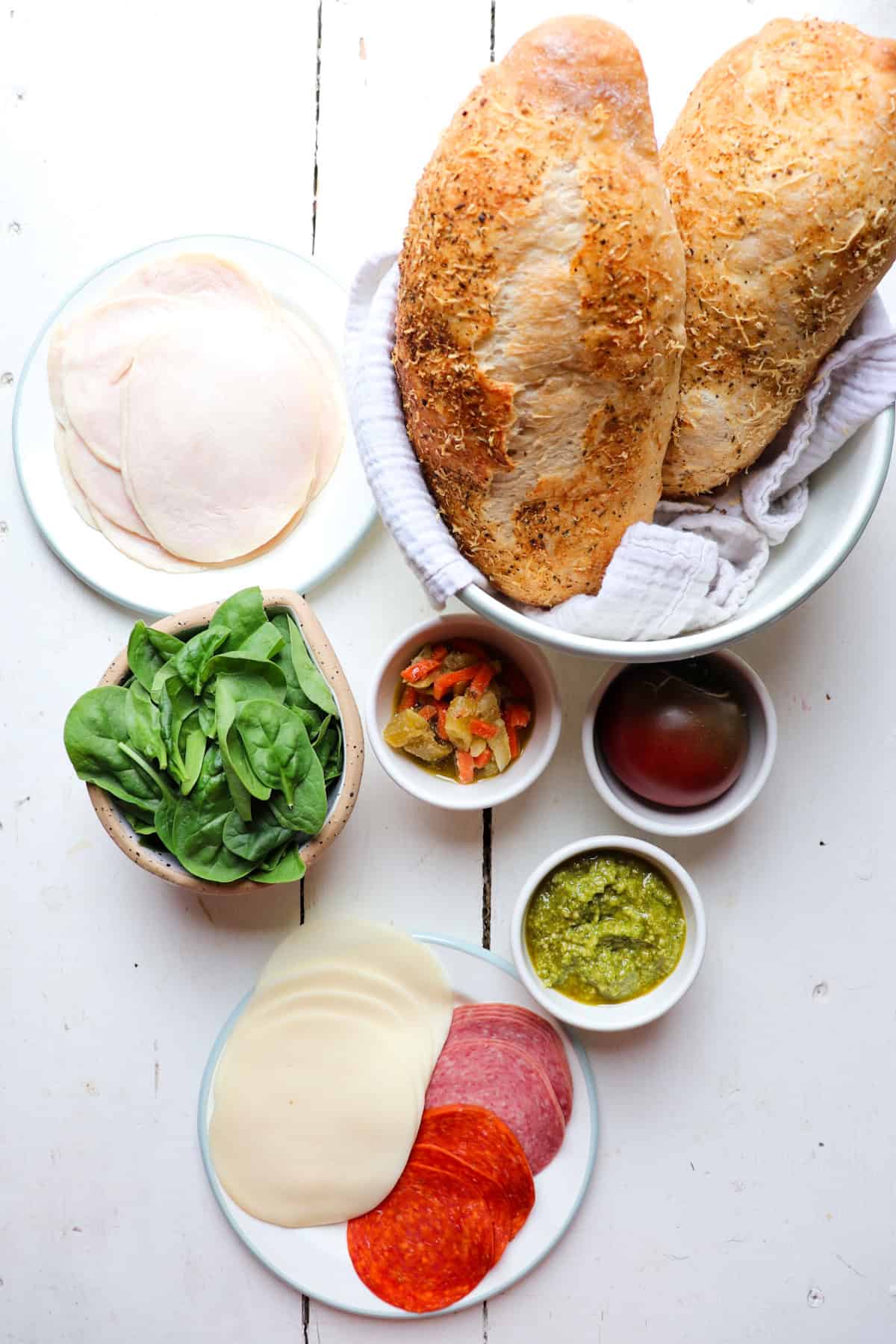 ingredients for pesto turkey sandwich on a white background.