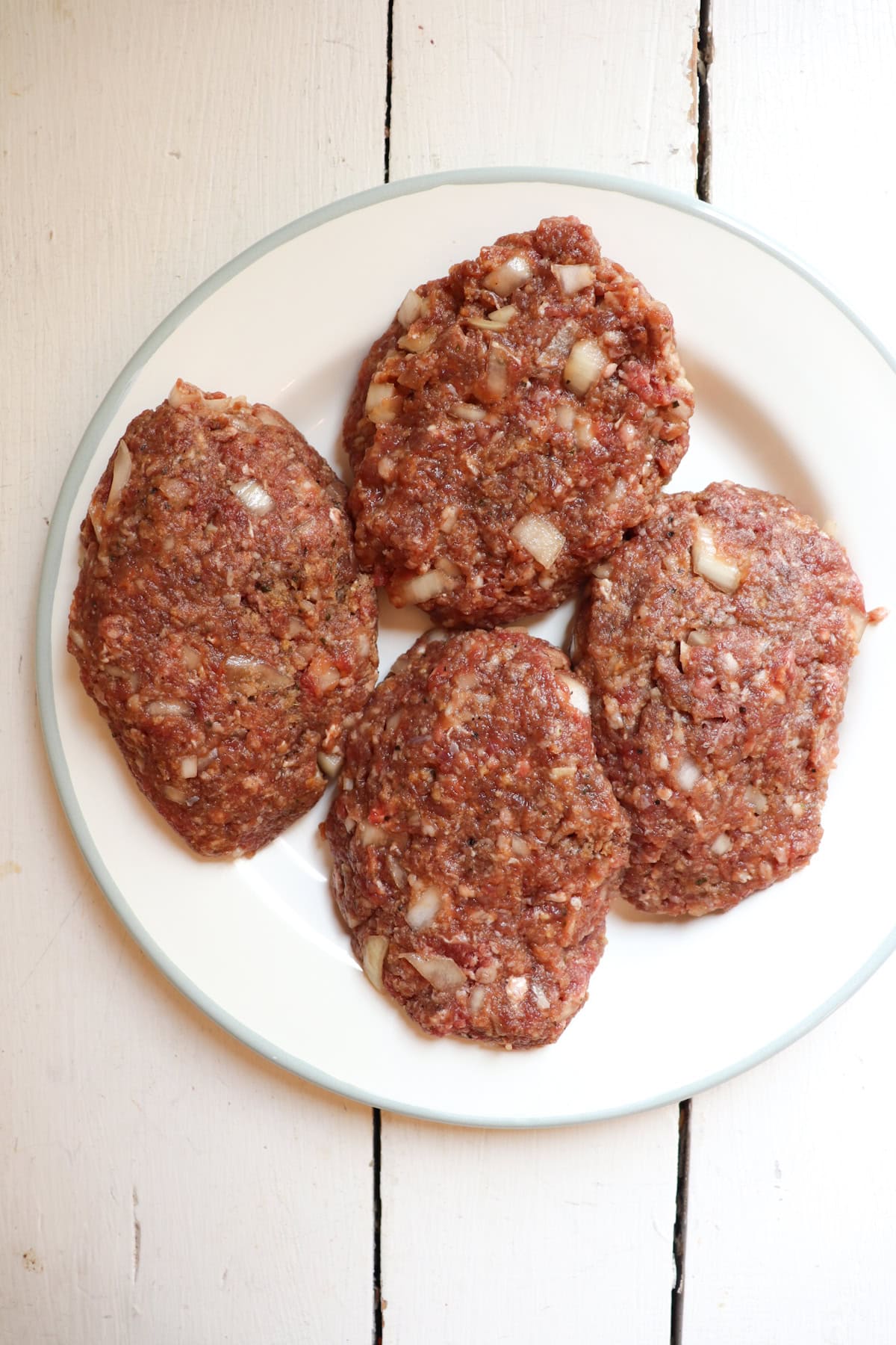 4 uncooked venison patties.