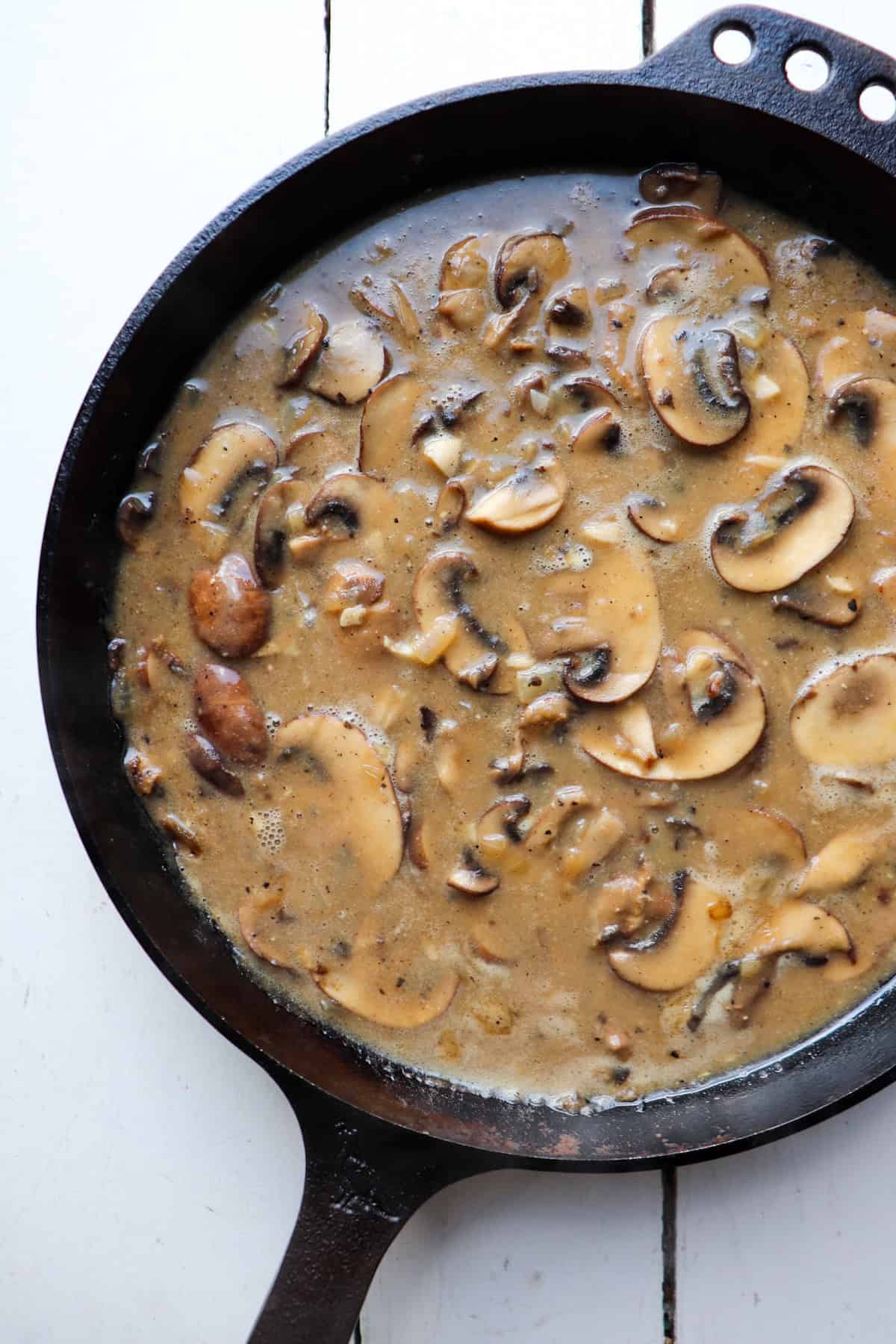 a skillet filled with mushroom sauce.