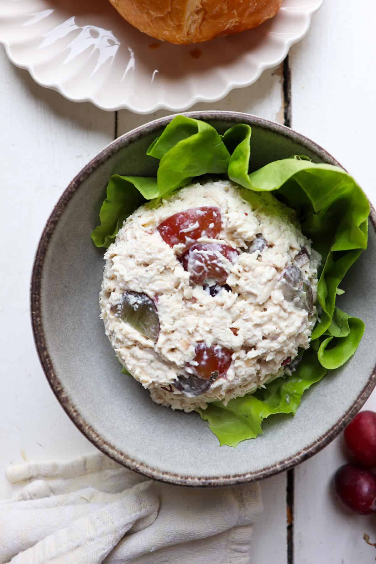 scoop of chicken salad on a bed of lettuce in a bowl.