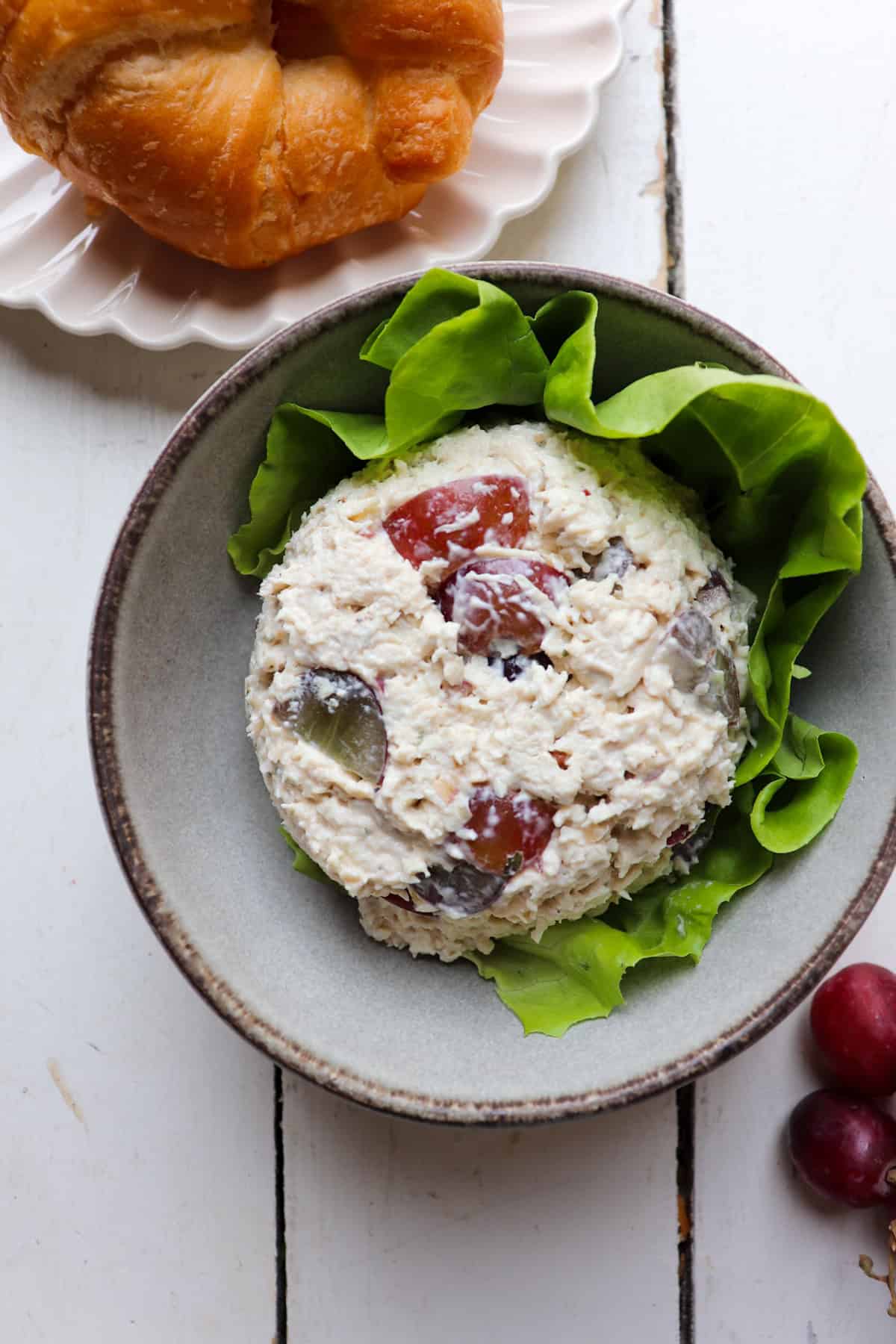 scoop of chicken salad on a bed of lettuce in a bowl.