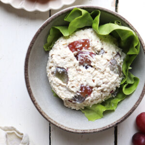 scoop of chicken salad on a bed of lettuce in a bowl.