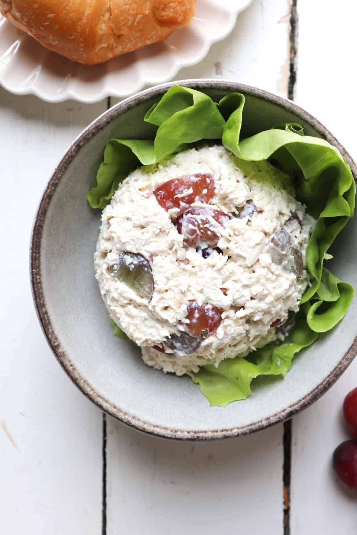 scoop of chicken salad on a bed of lettuce in a bowl.