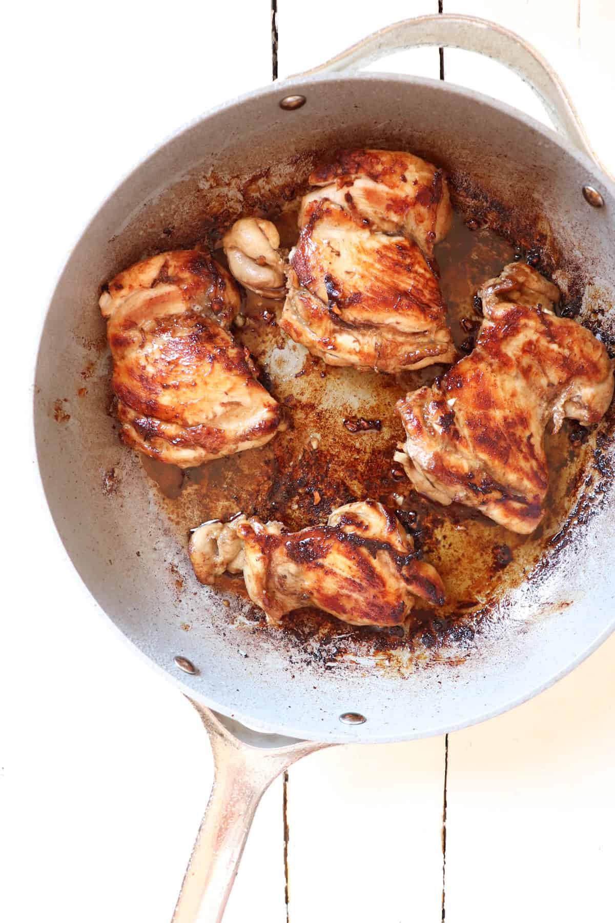 seared chicken thighs in a skillet.