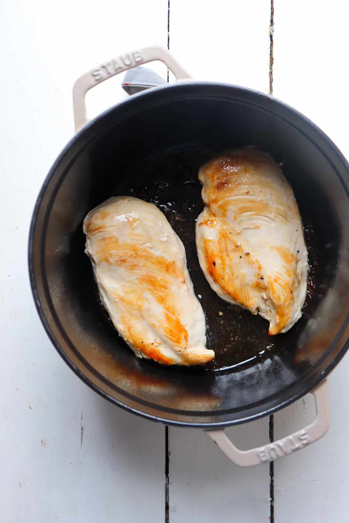 chicken breasts browning in a dutch oven.