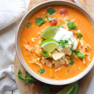 bowl of creamy chicken enchilada soup with garnishes.