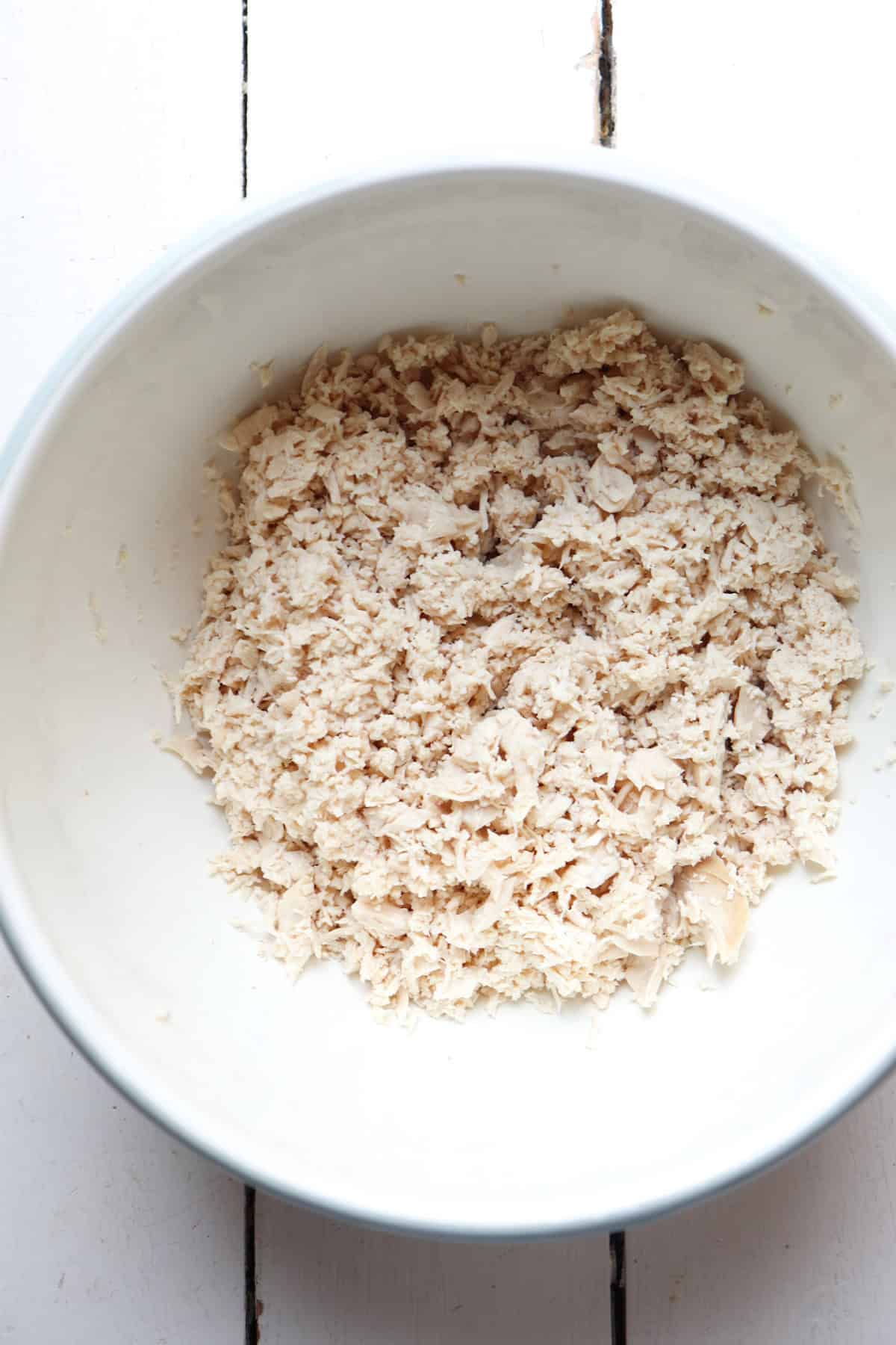 shredded chicken in a white bowl.