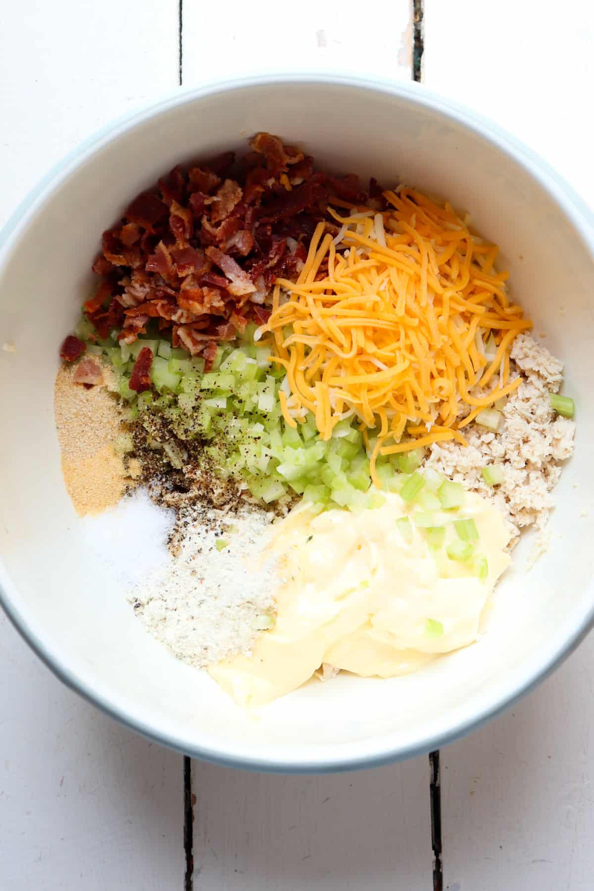 ingredients for chicken salad added to a bowl.