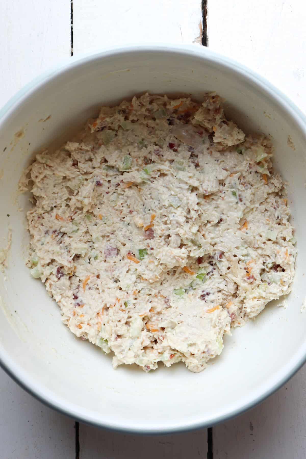 mixed sassy scotty chicken salad in a white bowl.