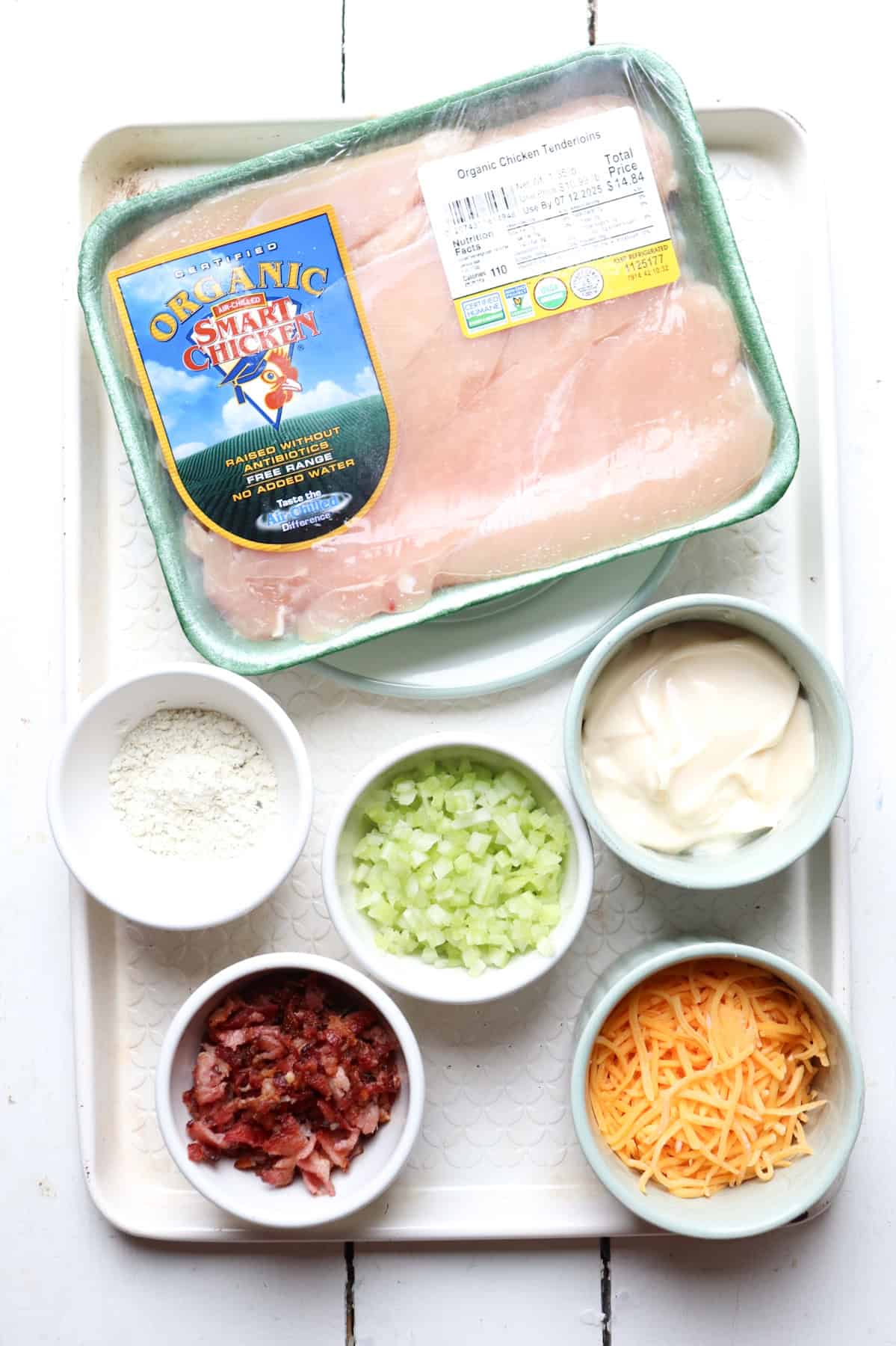 ingredients for chicken salad in bowls on a tray.