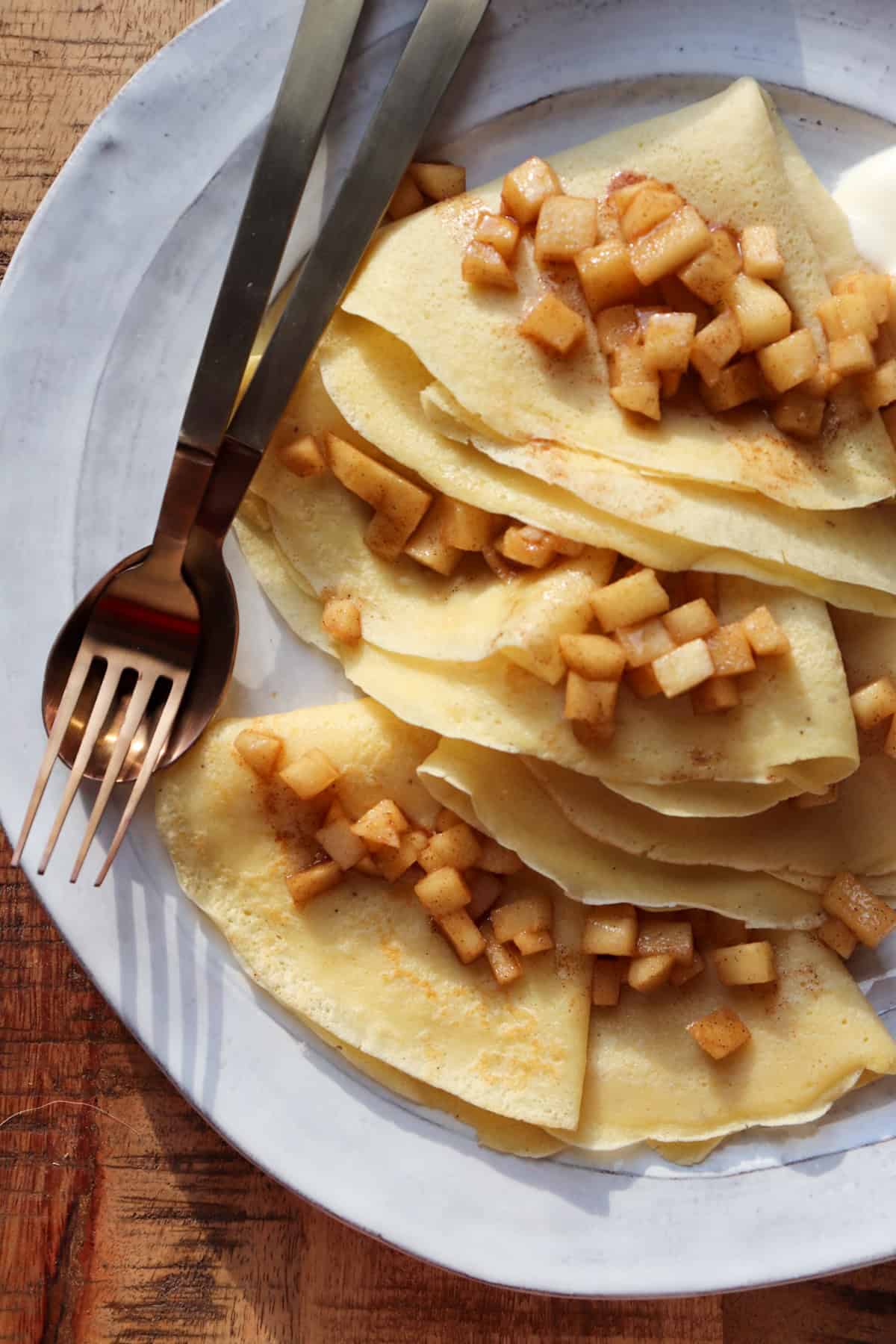 apple cinnamon crepe with utensils close up.