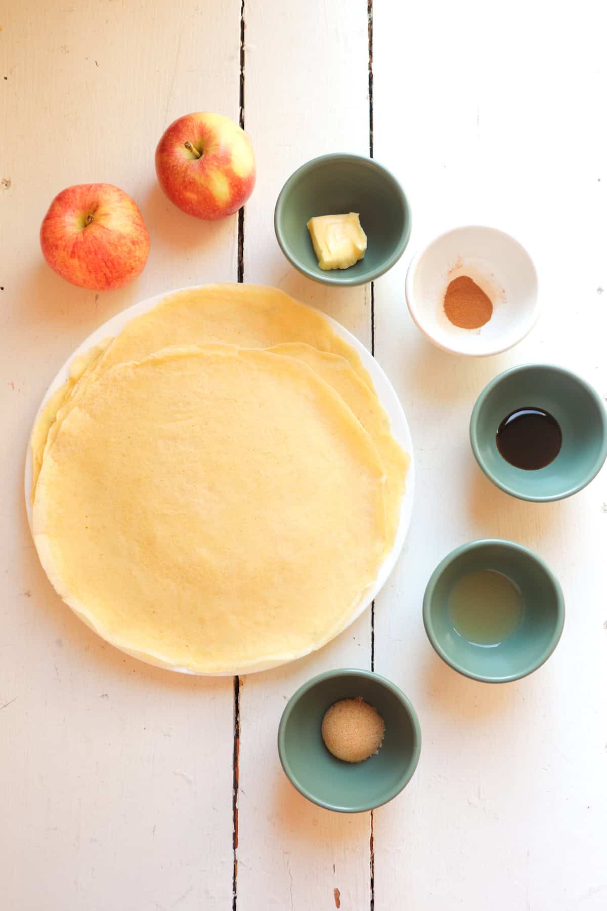 crepes on table with cinnamon apple ingredients.
