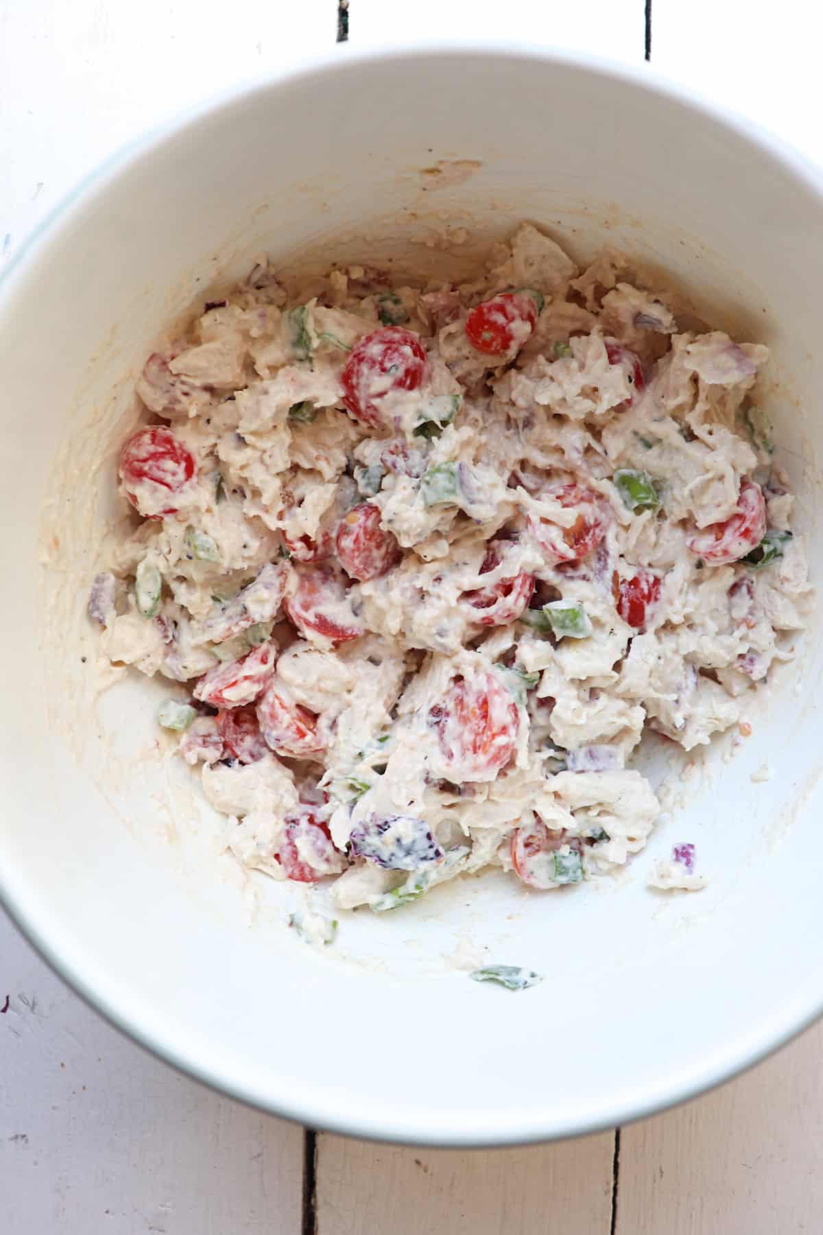 finished chicken salad in a white mixing bowl.