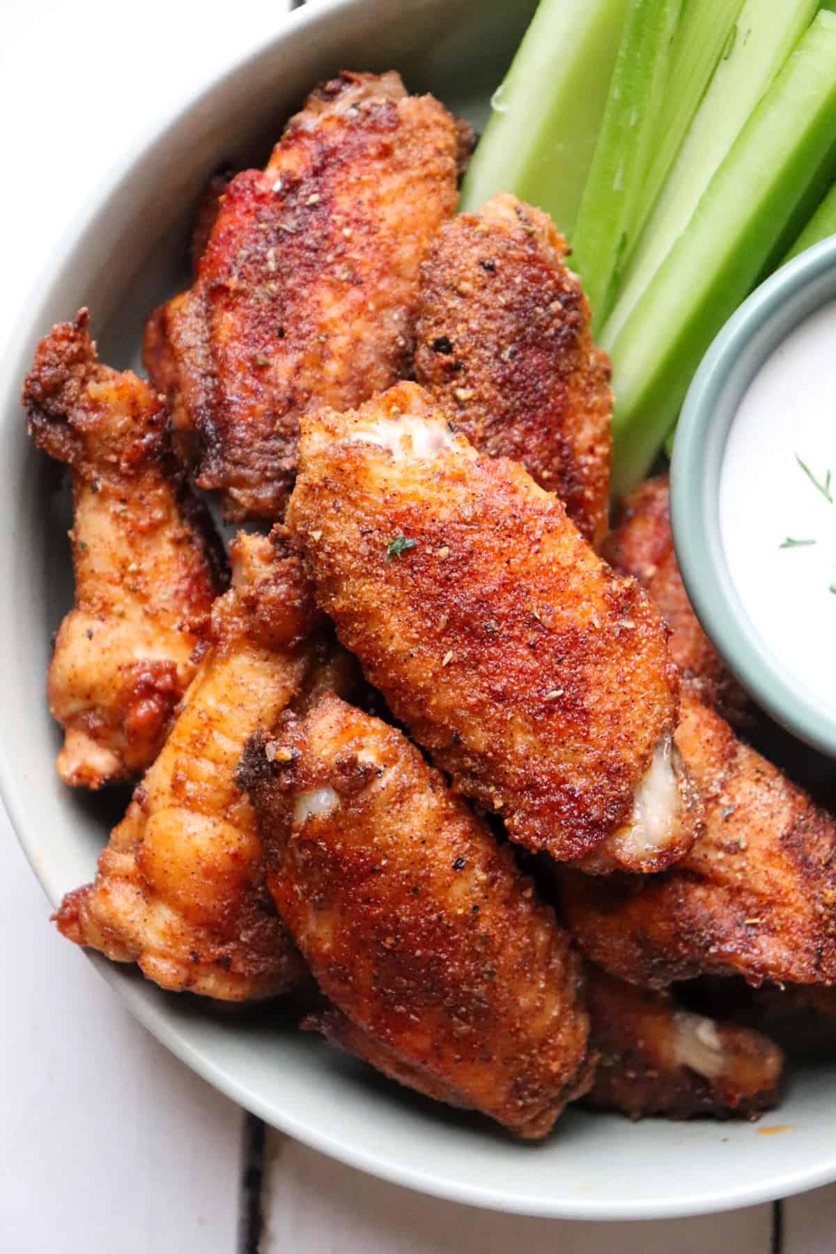 plate of chicken wings with ranch and celery to the side.