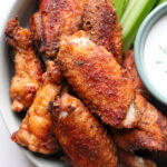 plate of chicken wings with ranch and celery to the side.