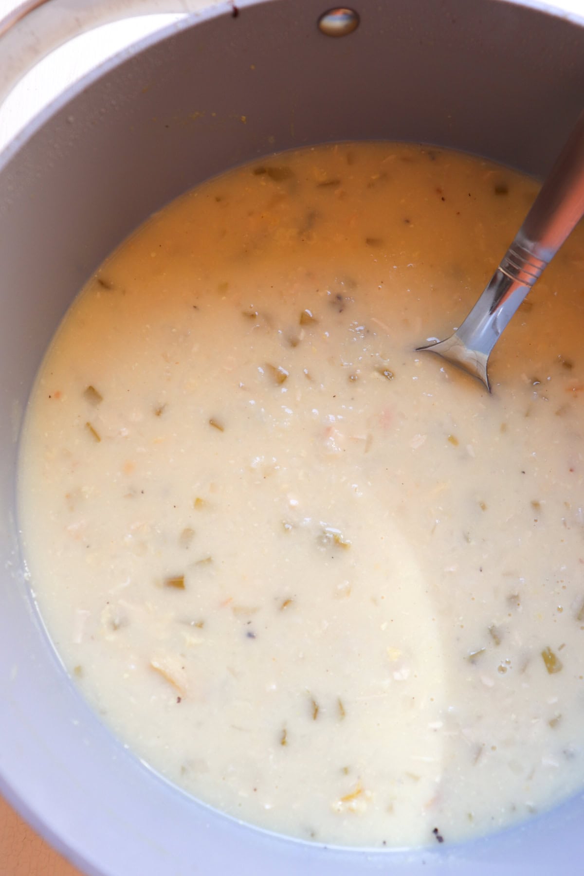 pot of Greek lemon rice soup with a spoon.