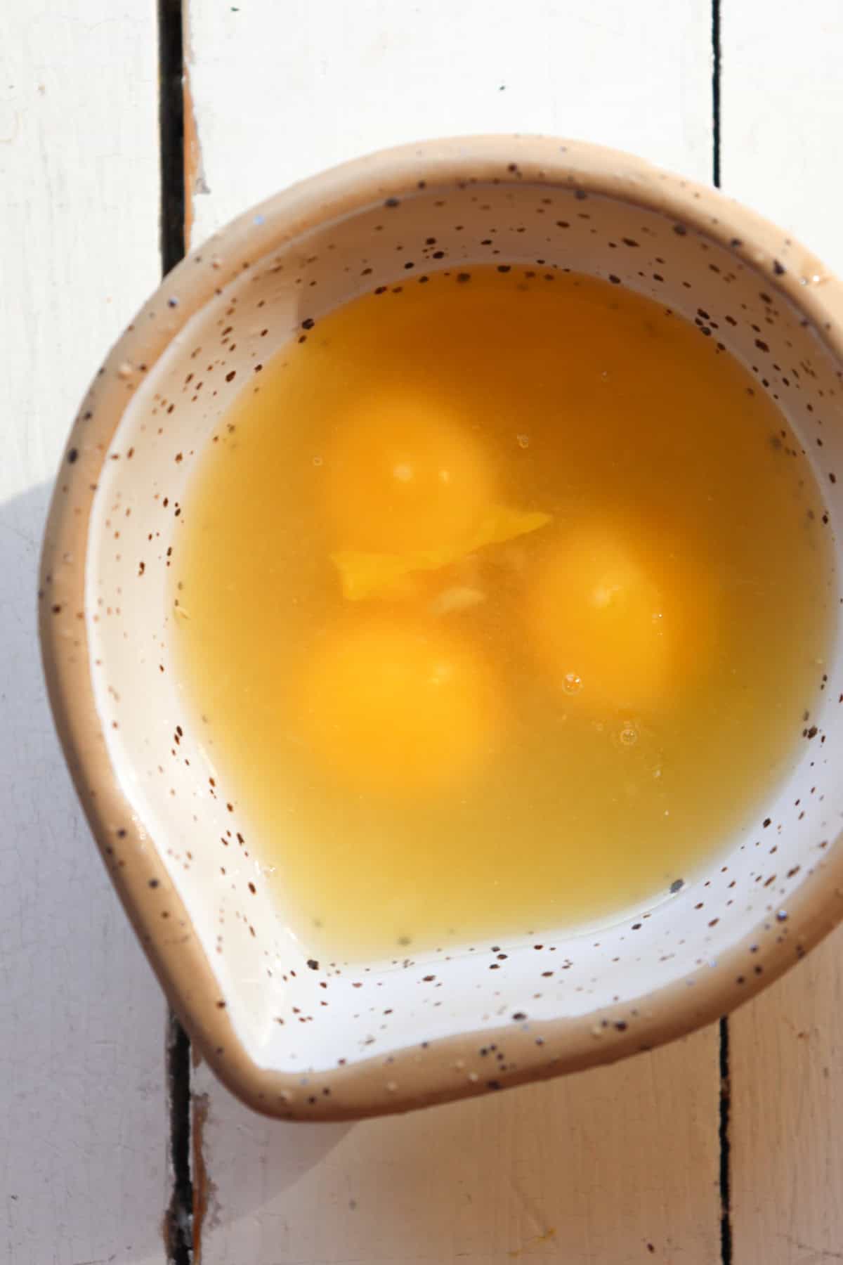 eggs in mixing bowl with chickenn stock.