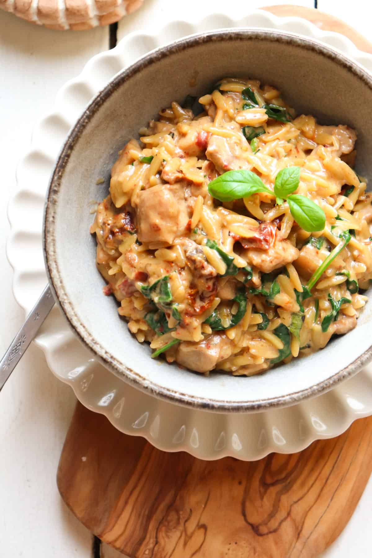 bowl of marry me chicken and orzo on a decorative plate.