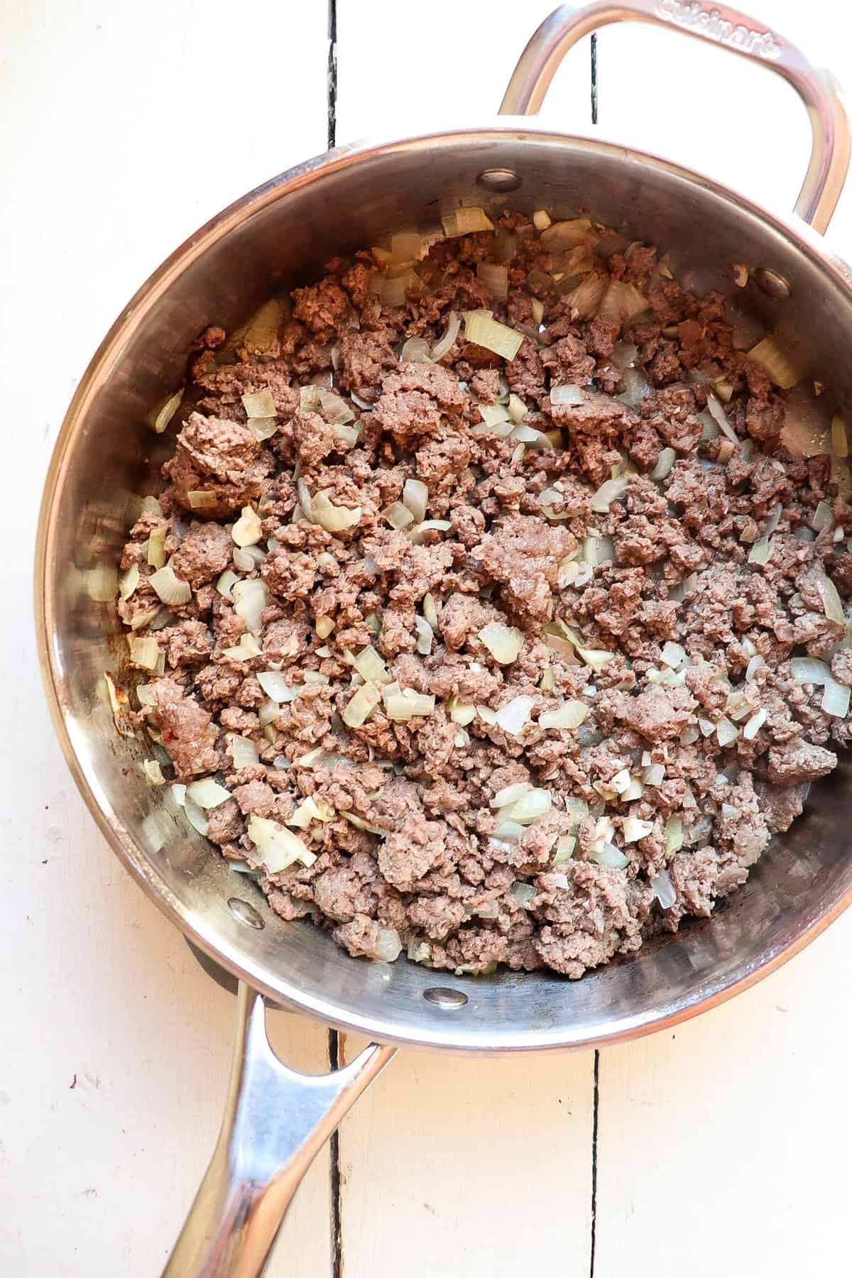 ground meat and ricotta cooked in a pan.