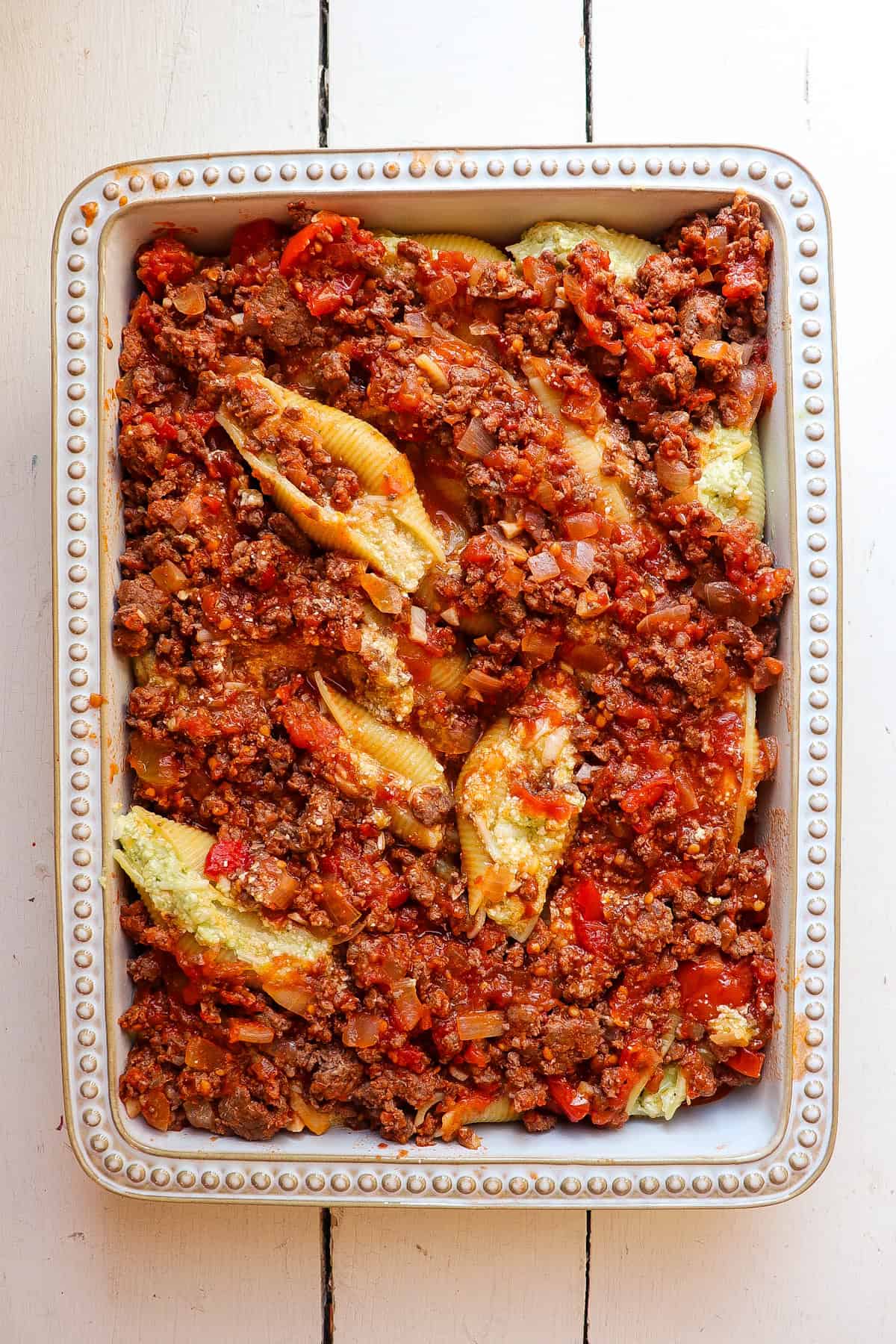 stuffed shells with tomato sauce in a baking pan.