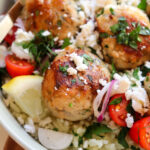 up close of chicken and feta meatballs with garnishes.