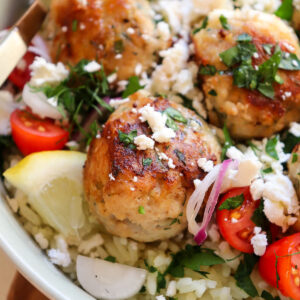 up close of chicken and feta meatballs with garnishes.