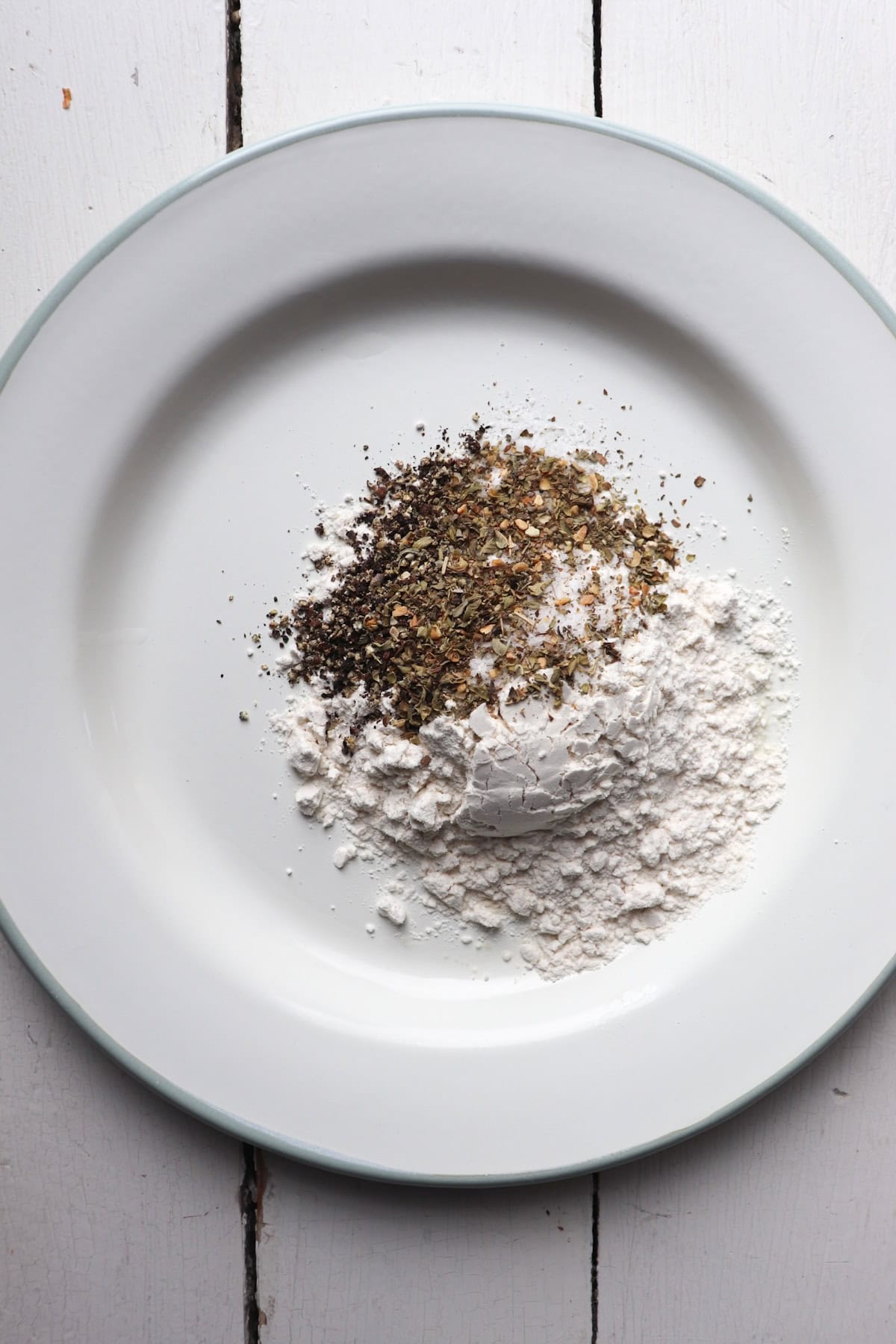 flour and seasonings for chicken on a plate.