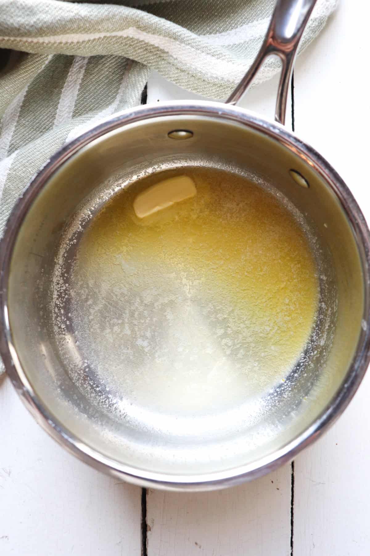 butter melting in stainless steel pan.