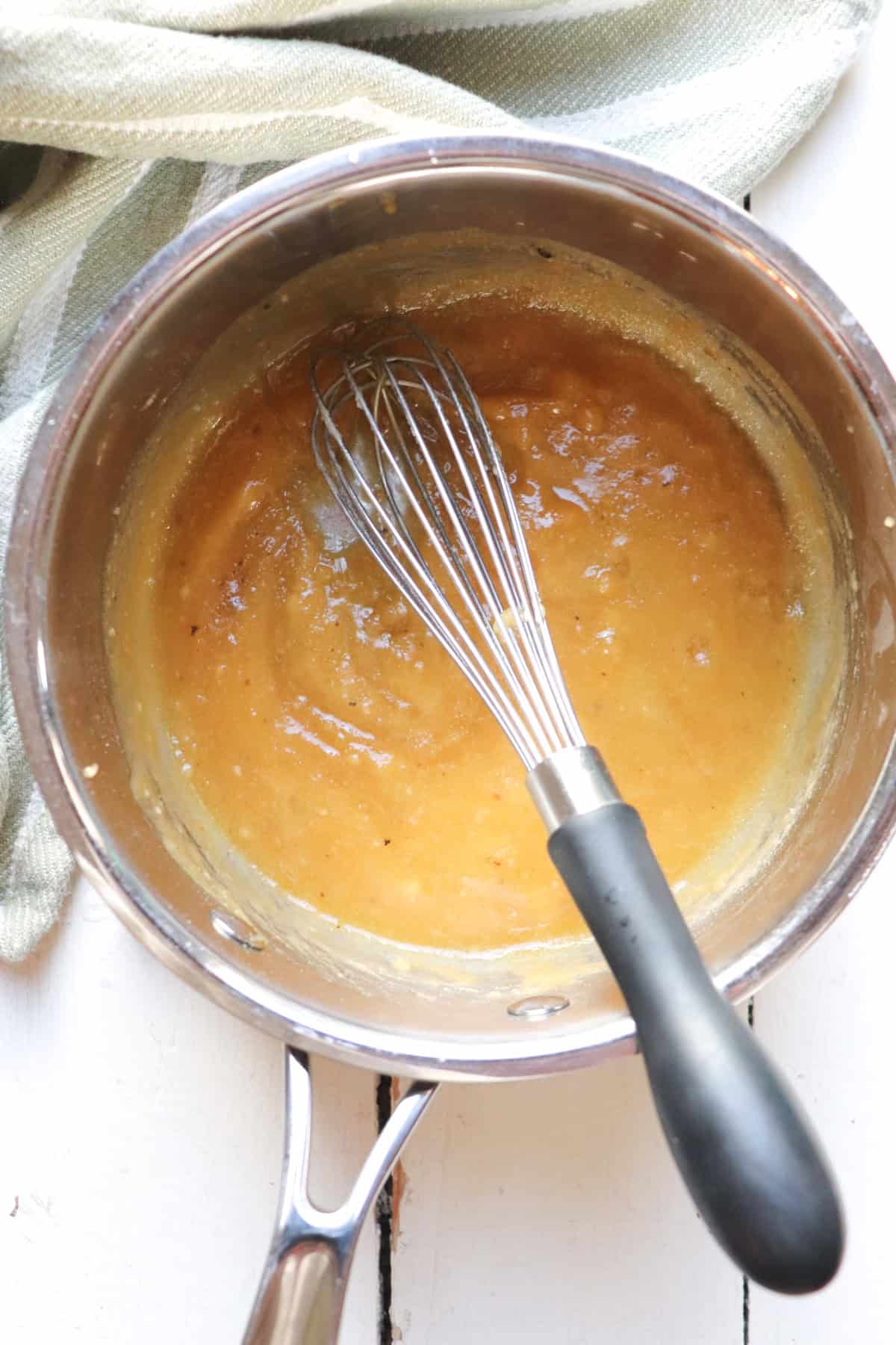 whisking roux in a pot.