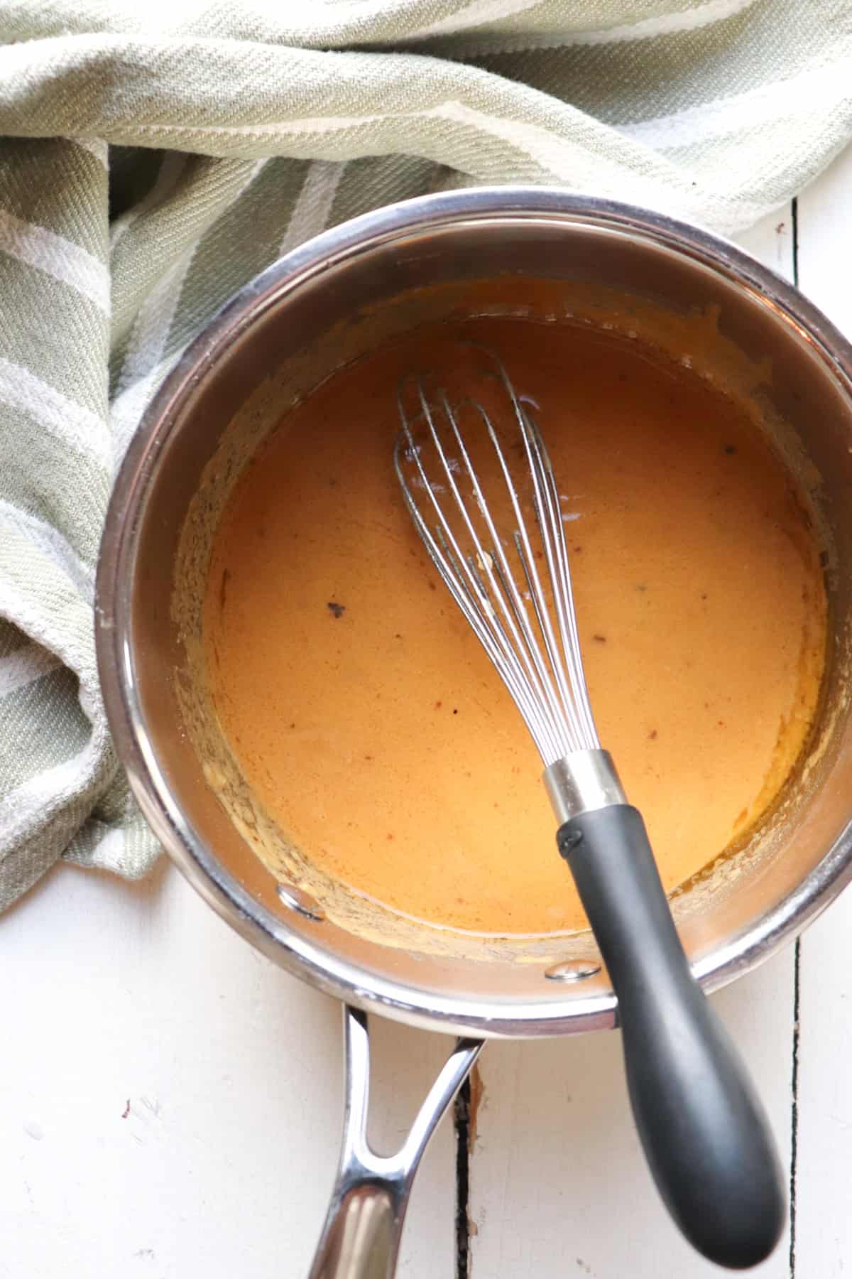 adding drippings and whisking in pot.