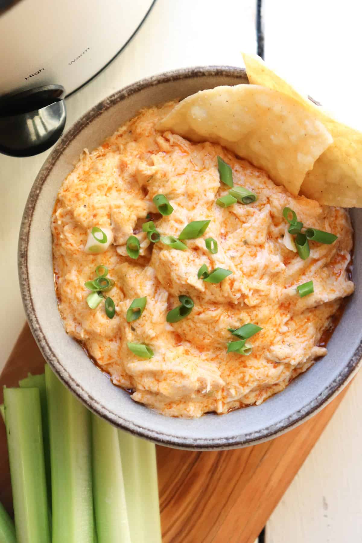 slow cooker buffalo chicken dip with tortilla chips.