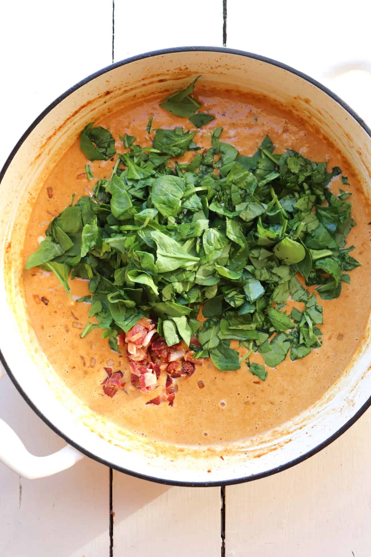 cream sauce in pot with spinach.