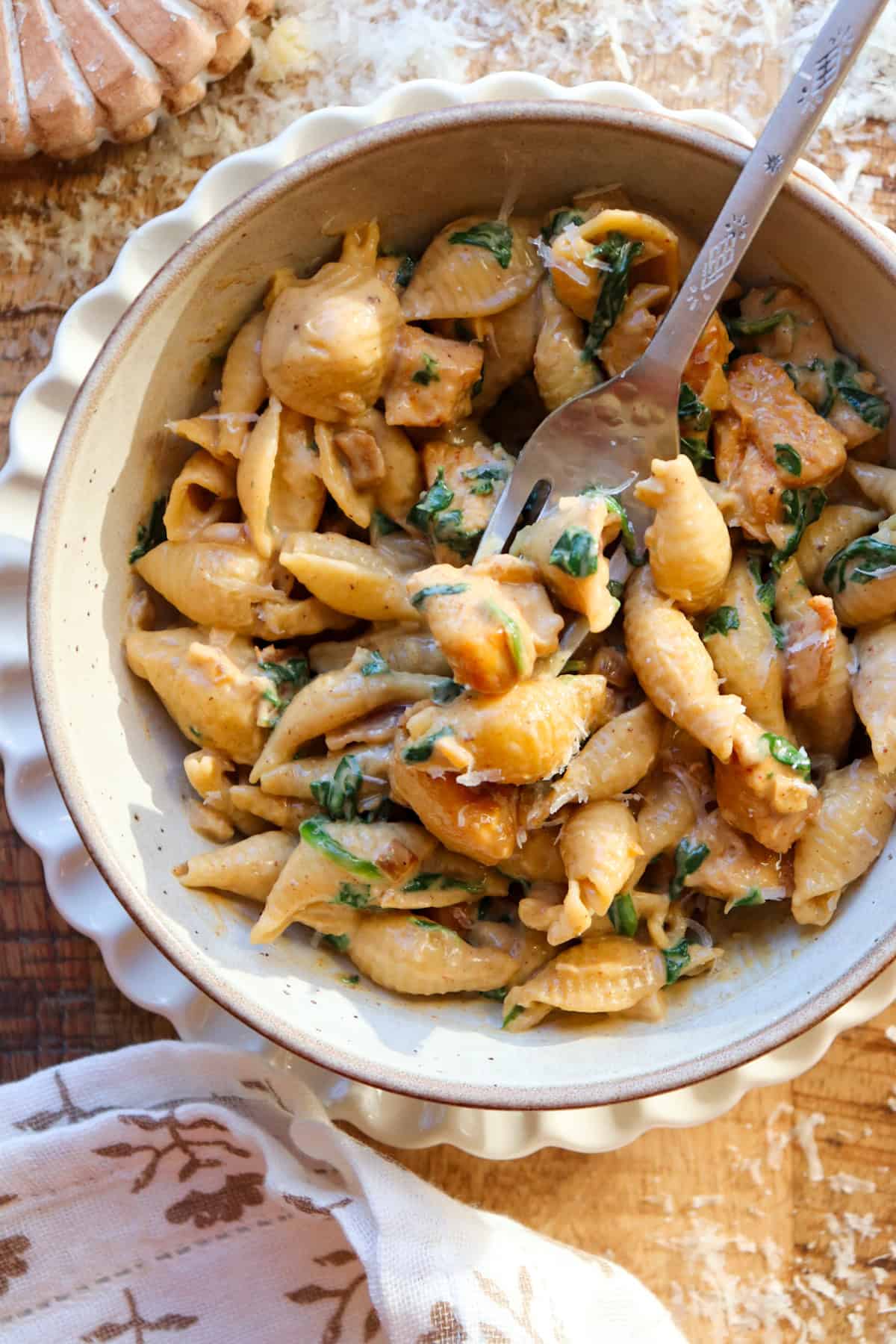 creamy chicken and garlic pasta in bowl with spoon.