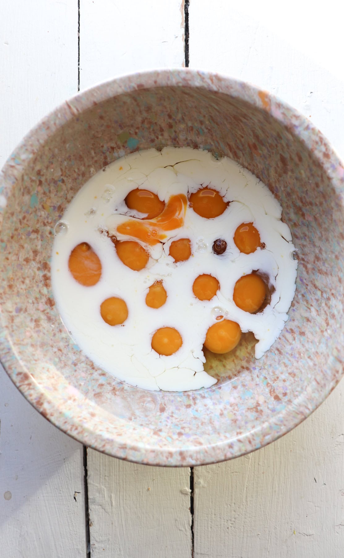 bowl of cracked eggs and milk.