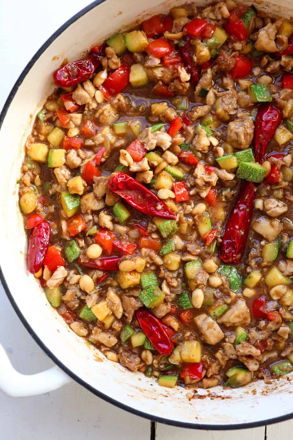 finished kung pao chicken in a white enamel skillet.