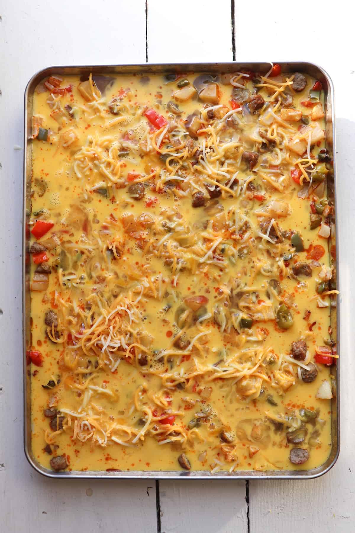 sheet pan with baked eggs and vegetables.