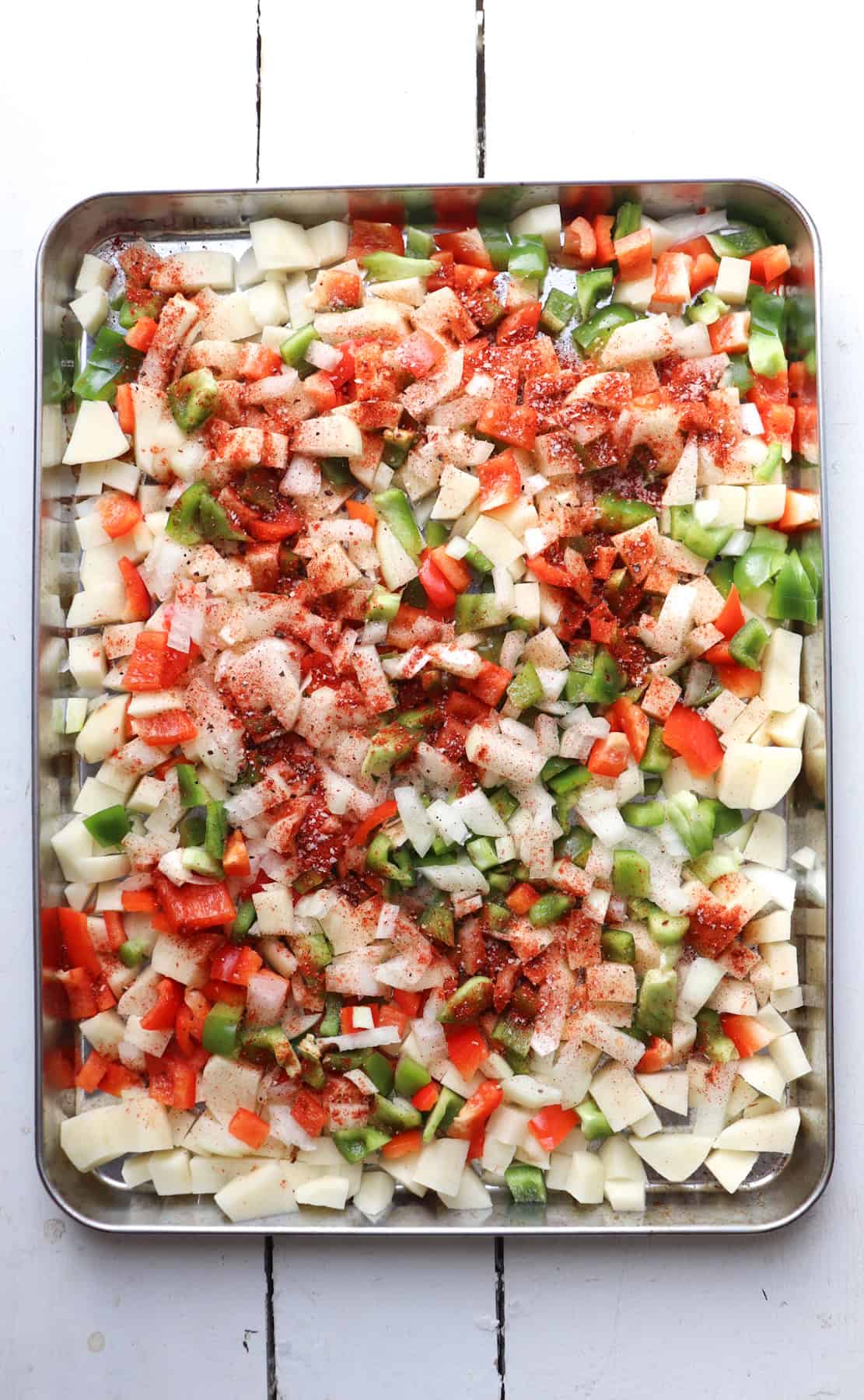 ingredients on sheet pan for breakfast burritos with potatoes.