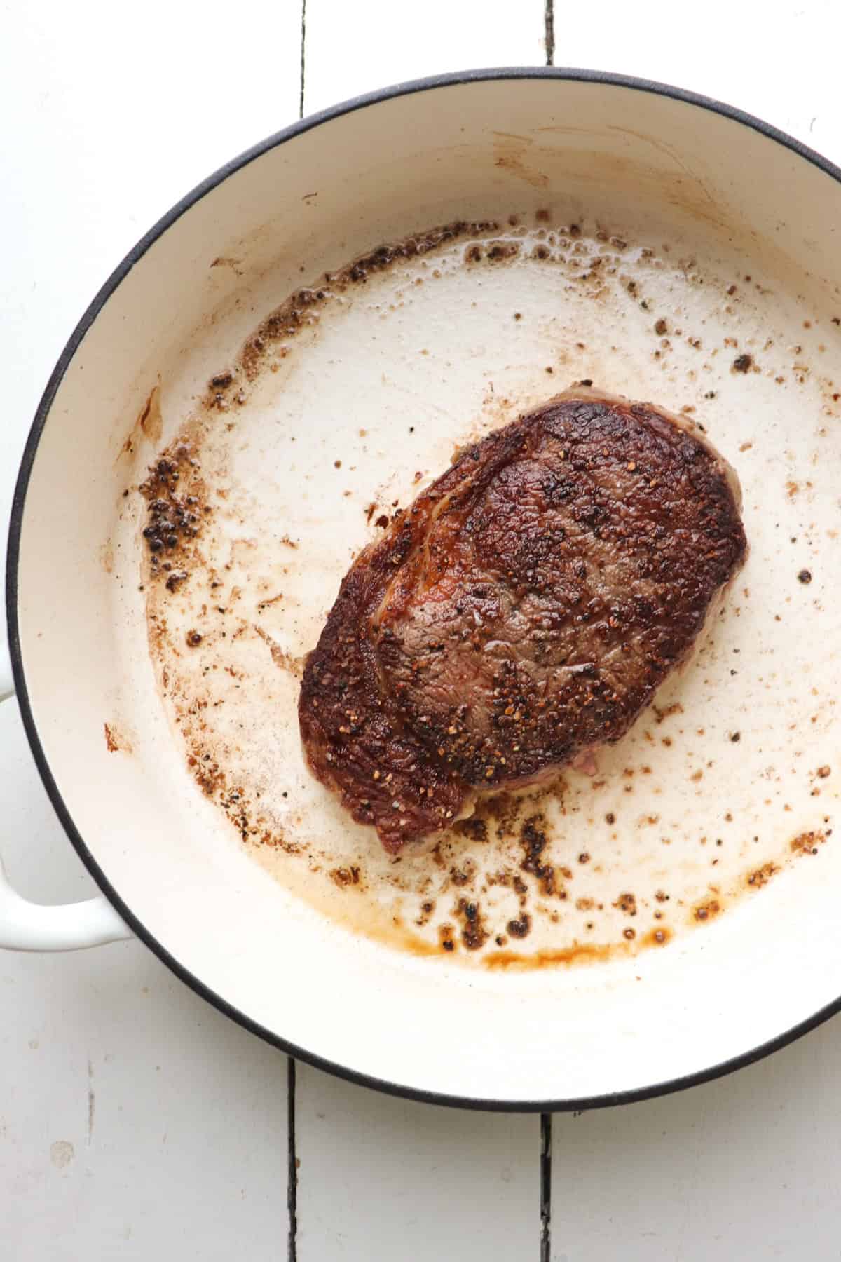 cooked steak in pan.