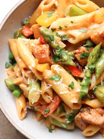 bowl of pasta with veggies in a spicy cream sauce.