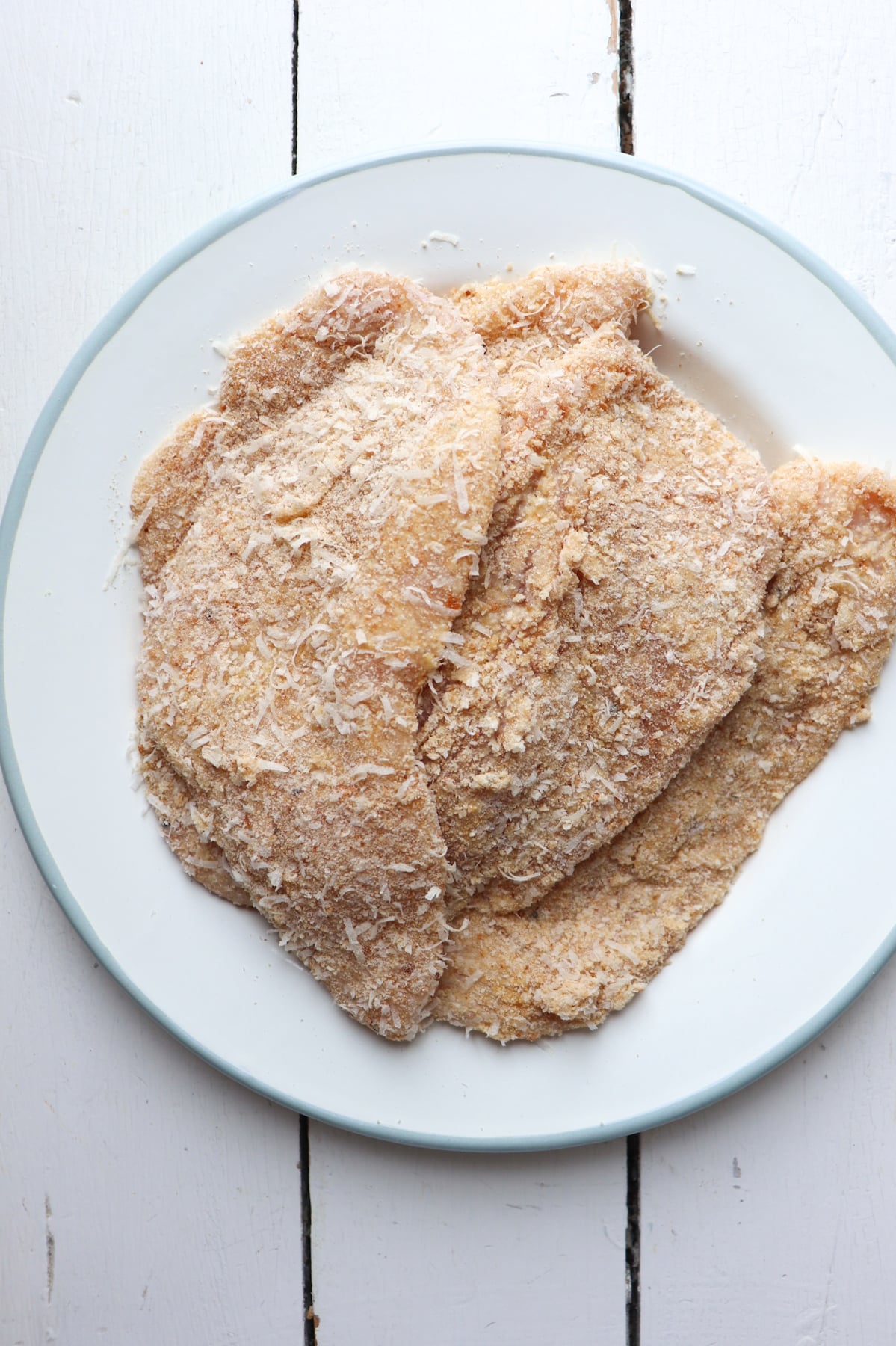 breaded chicken cutlets on on plate before cooking.