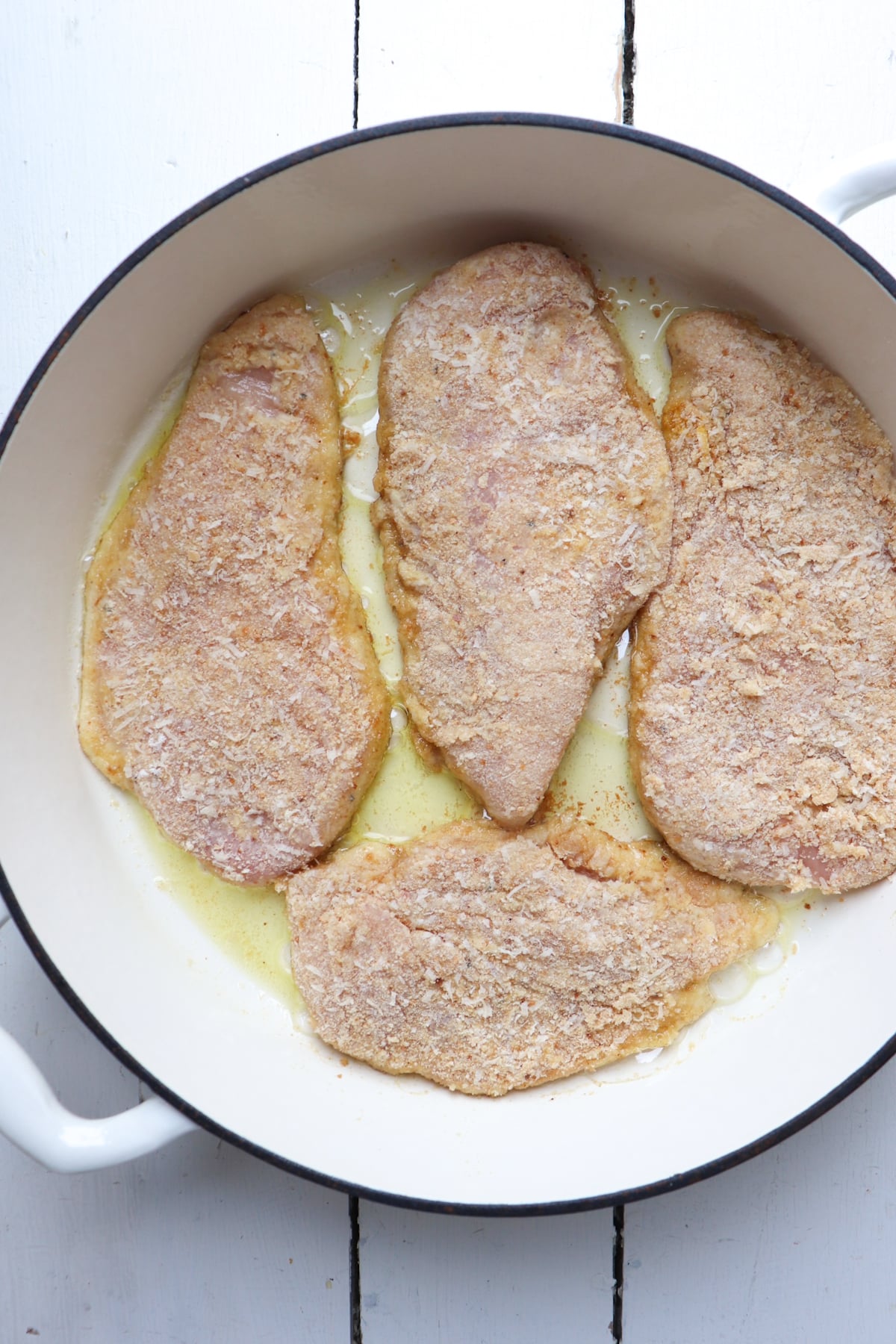 chicken cutlets that have been breaded cooking in a pan.