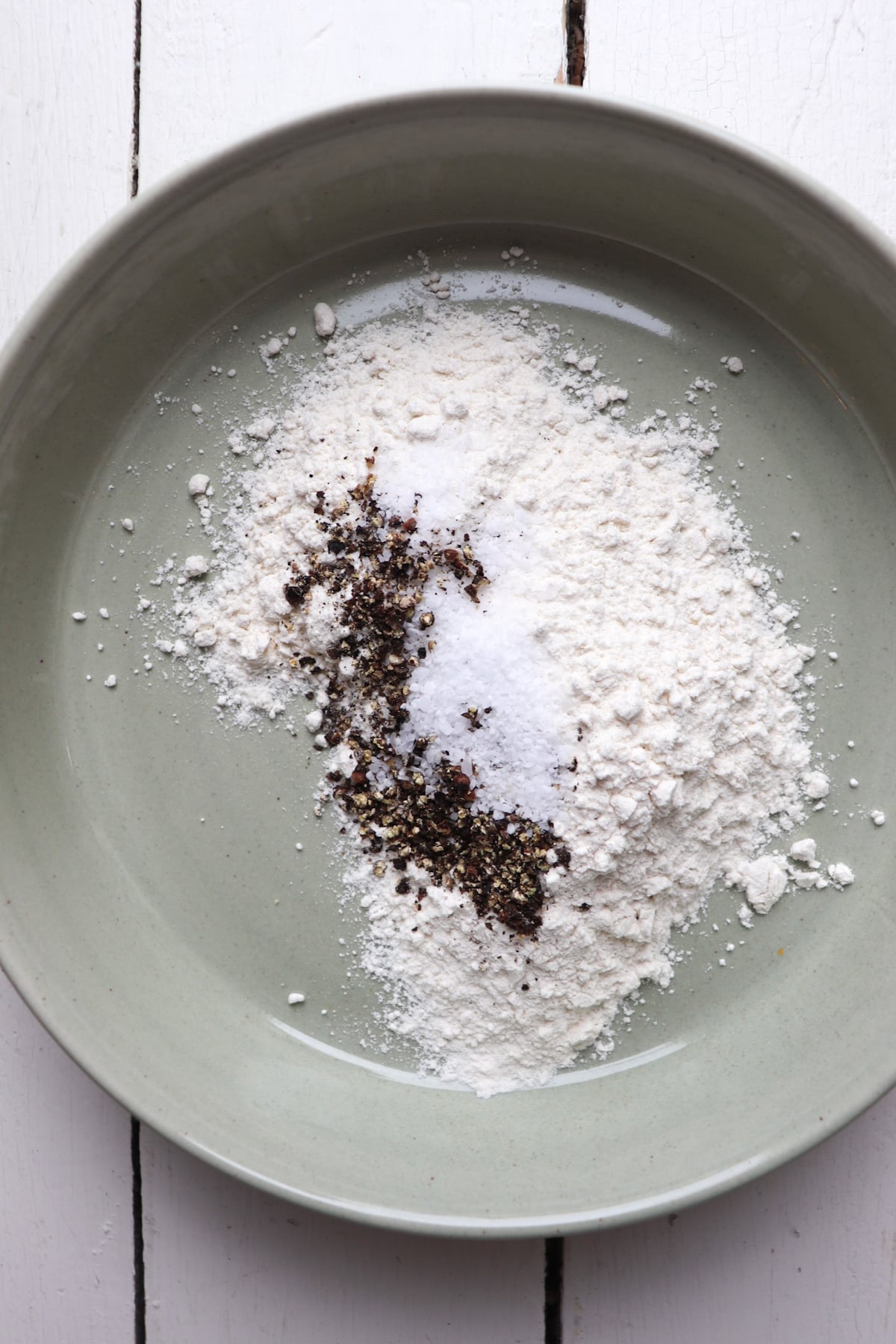 seasoned flour in a low green bowl.