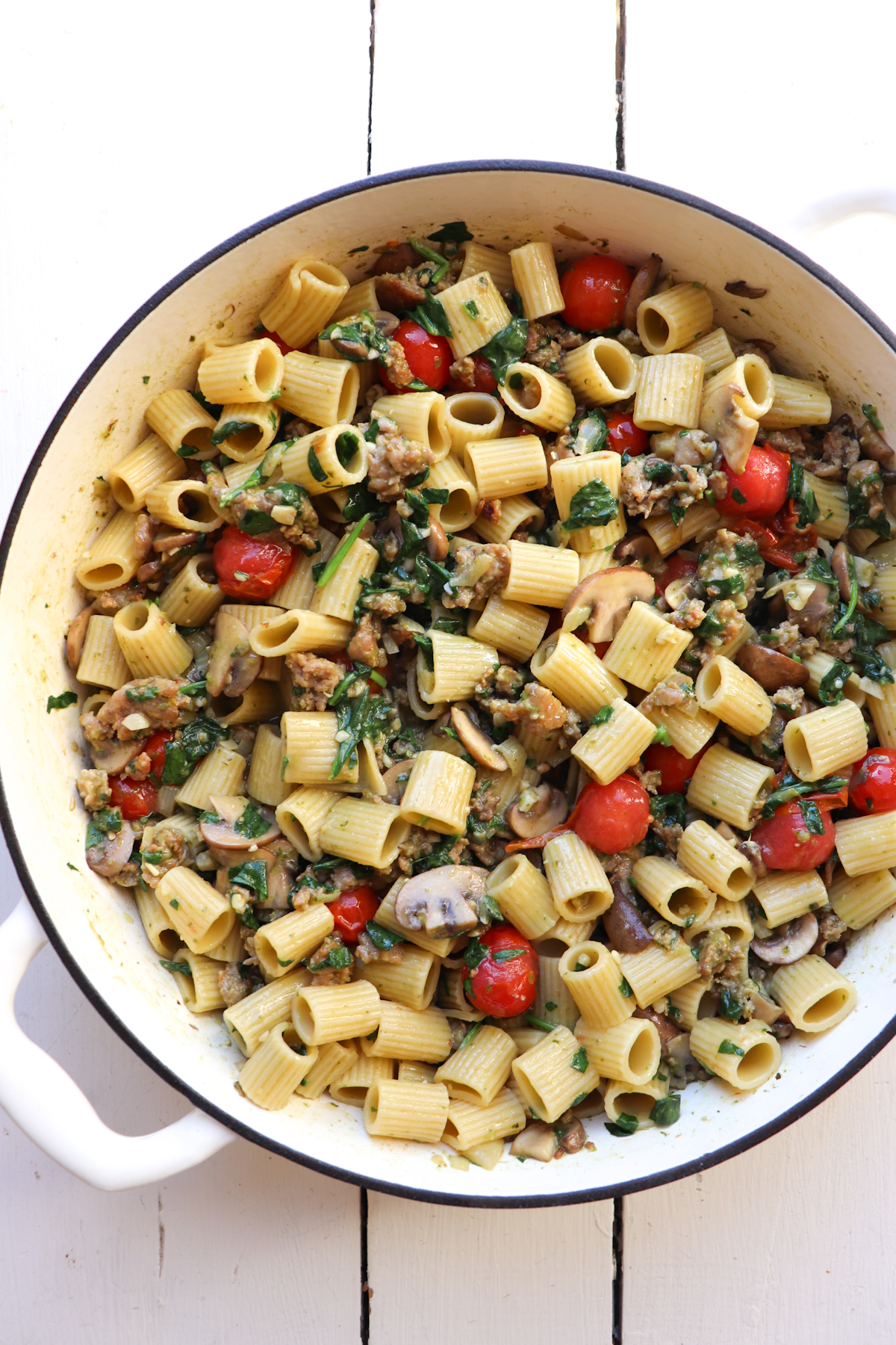 finished sausage and mushroom pasta in a white dutch oven.