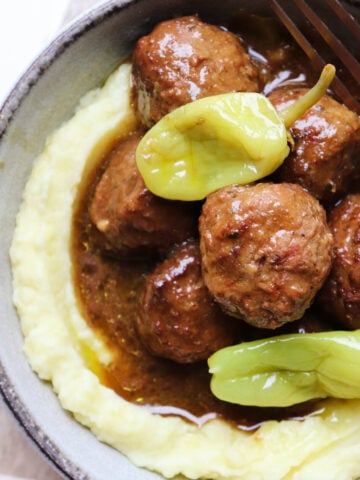 bowl of mississippi meatballs on a bed of mashed potatoes.